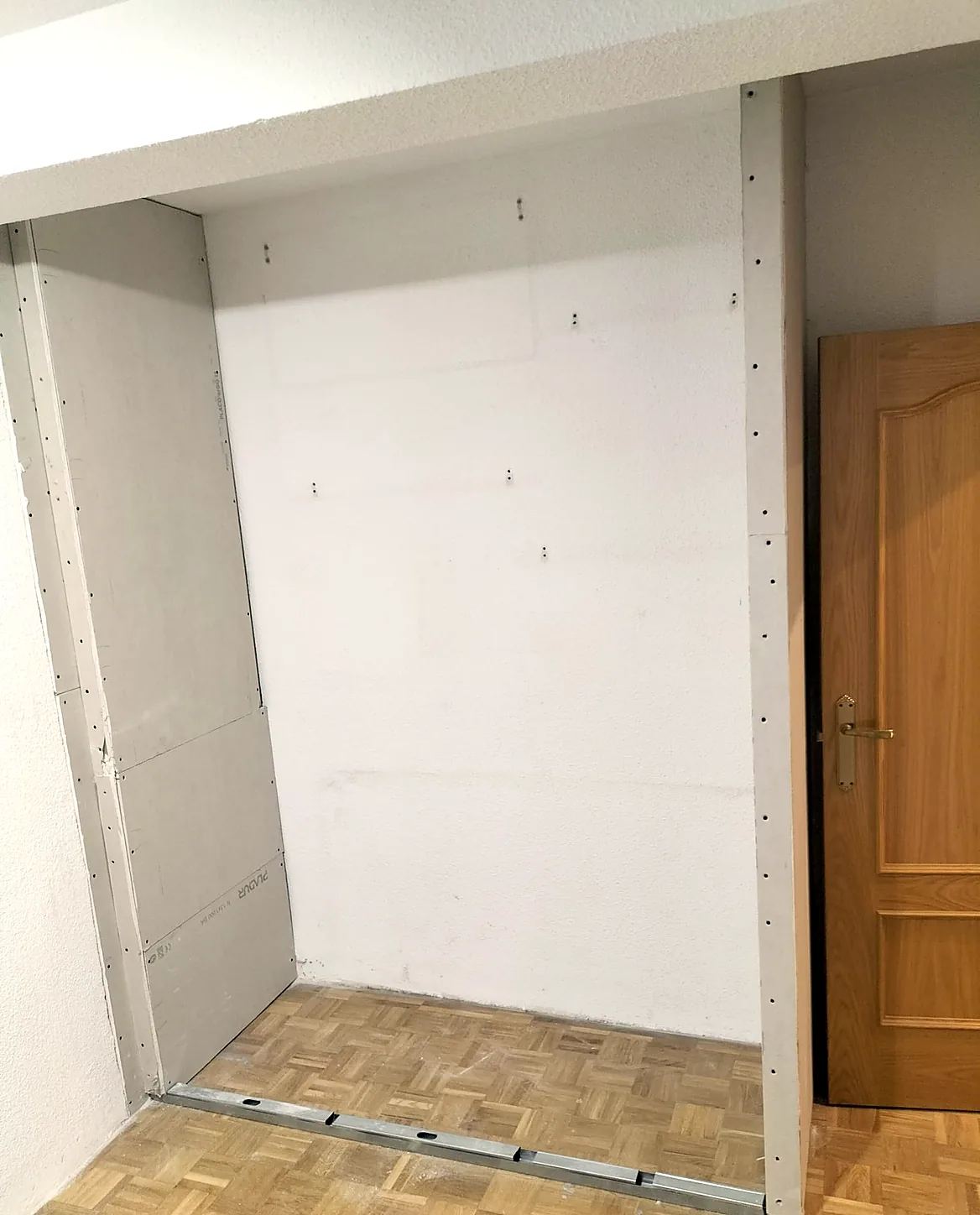Hueco del armario empotrado cerrado con placa de yeso laminado durante la obra